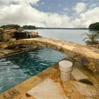 Stone arch bridge over a pool toward a lake