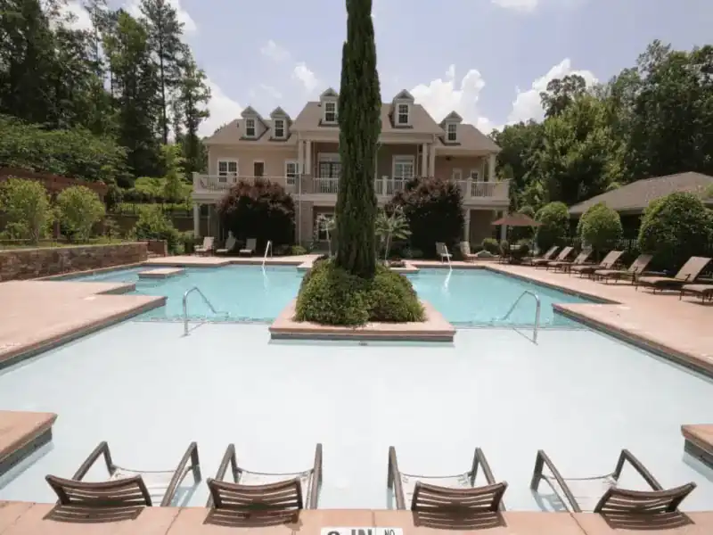 Community pool with a central planter island and loungers along the deck