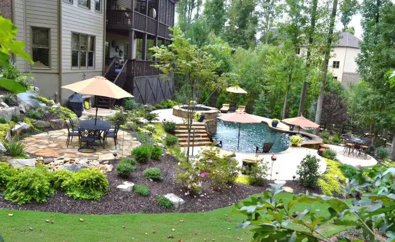 Rock-and-plant spa and waterfall garden with patio umbrellas